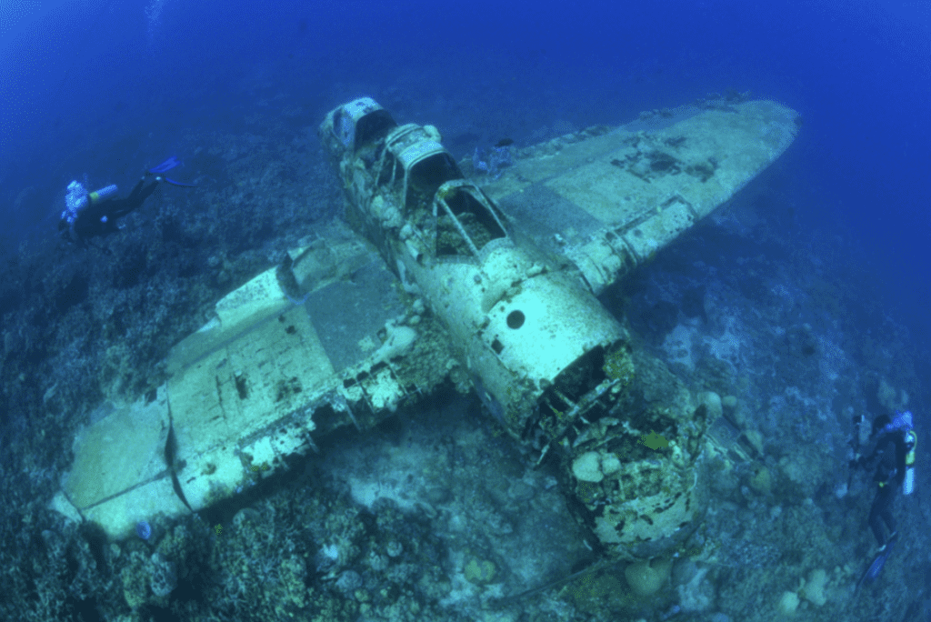 Airplane underwater with scuba divers around it